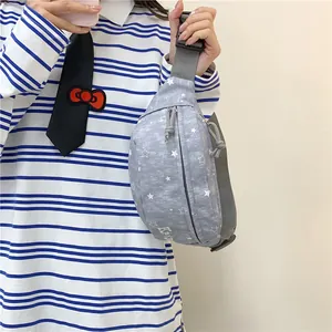 Close-up detail of gray chest bag featuring white star patterns and an adjustable strap