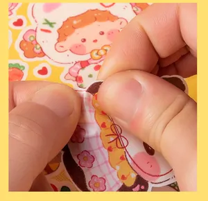 Close-up showing the peeling of a cute cartoon PVC sticker for scrapbooking and DIY decor