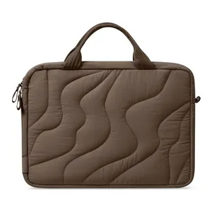 Close-up of brown quilted laptop bag with wave pattern stitching detail