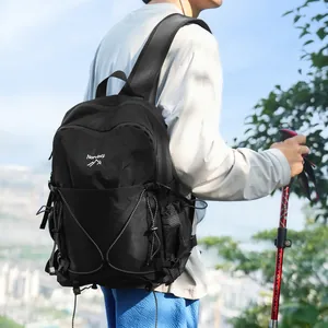 Vue arrière d'un homme portant un sac à dos de randonnée noir avec un bâton de marche