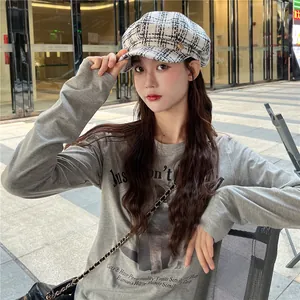 Detailed view of a black and white checkered newsboy cap in British style for women