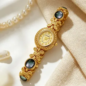 Elegante reloj de pulsera dorado con incrustaciones de concha oscura y fondo de perlas.