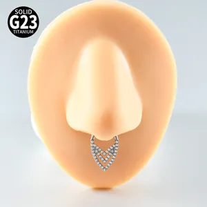 Macro detail of G23 titanium V-shaped zircon septum ring shown on a silicone nose model