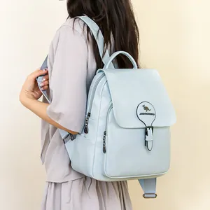 Vue détaillée d'un sac à dos de voyage bleu clair pour femme porté par un mannequin