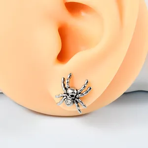 Detailansicht eines gotischen Spinne-Ohrsteckers mit Totenkopf und klarem Kristallakzent.