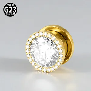 Macro detail of gold-plated G23 titanium ear plug with a sparkling zirconia halo
