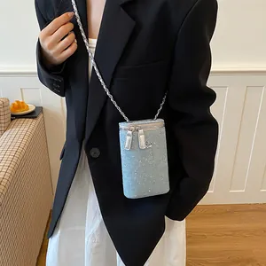 Detail view of denim crossbody phone bag with rhinestones and chain strap.