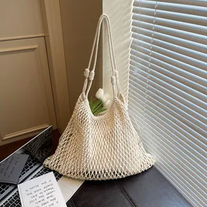 Dettaglio di una borsa a tracolla in rete intrecciata stile francese con un tulipano.