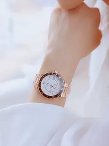 Vista detallada de un elegante reloj de mujer en acero oro rosa con bisel azul oscuro
