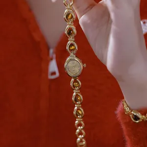 Primer plano de reloj pulsera vintage de oro con piedras de ojo de tigre naturales