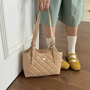 Elegante beige gesteppte Tragetasche, gehalten in einer lässigen Lifestyle-Umgebung