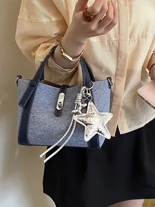 Denim style large capacity bucket bag with star charm and dark blue trim accents