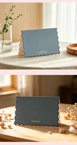 Close-up of Morandi blue and dark gray thank you cards with gold foil and scalloped edges.