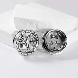Close-up van vintage zilveren vleermuis oortunnels met gedetailleerd design