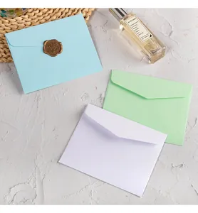 Close-up of colorful mini envelopes in pastel blue, green and white with gold wax seal