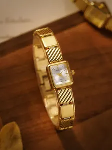 Vista detallada del reloj cuadrado de oro vintage con correa de eslabones decorativa