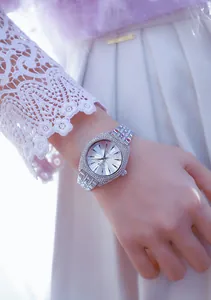 Primer plano de un reloj de lujo plateado para mujer con bisel de cristal