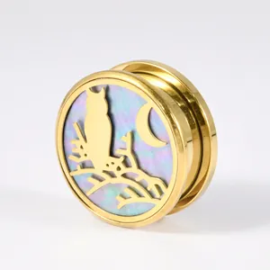 Makroansicht von goldfarbenem Edelstahlohrstecker mit Eulen- und Muschel-Inlay