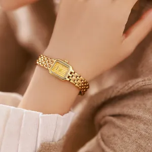 Nahaufnahme einer eleganten goldenen Vintage-Uhr am Handgelenk mit feinem Gliederkettenarmband