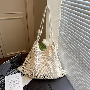 Dettaglio di stile di una borsa a tracolla tessuta a traforo con tulipani bianchi.