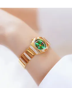 Detailopname van een luxe gouden dameshorloge met groene wijzerplaat en kristallen op de pols