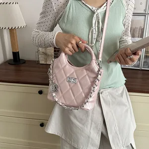 Detail view of stylish pink quilted bucket bag with elegant silver chain and handle
