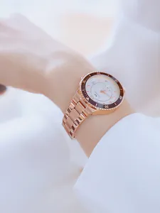 Vista detallada de un reloj de mujer de acero oro rosa con esfera blanca en muñeca