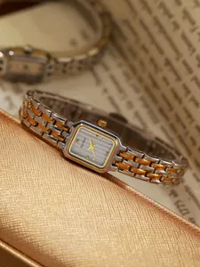 Makro-Detailansicht einer rechteckigen Vintage-Uhr mit zweifarbigem Armband in Silber und Gold