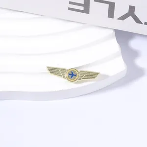 Detailansicht einer Vintage-Pilotenflügel-Brosche in Gold mit blauem Flugzeug-Emblem.