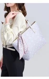Detailopname van een stijlvolle tote bag met geometrisch patroon en zijden sjaal.