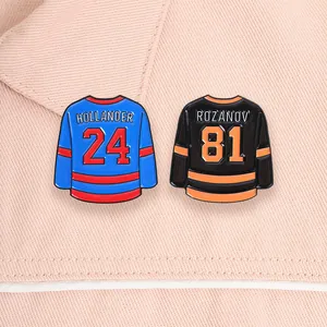 Detail view of two hockey jersey enamel pins with Hollander 24 and Rozanov 81 names.