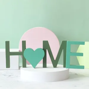 Gros plan sur les lettres HOME en bois avec un cœur pour une décoration de table minimaliste