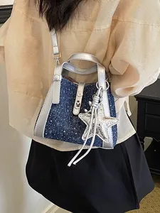 Chic blue denim bucket bag for women featuring silver trim and a metallic star charm