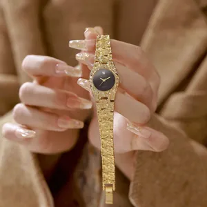 Elegante reloj vintage de mujer con brazalete de textura de lava dorada y esfera negra