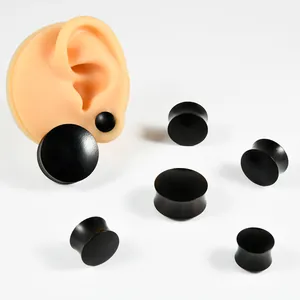 Detailed macro view of solid ebony wood ear expansion plugs in various gauge sizes.