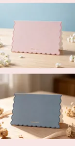Detail of pink and blue scalloped thank you cards with gold foil lettering on wood.
