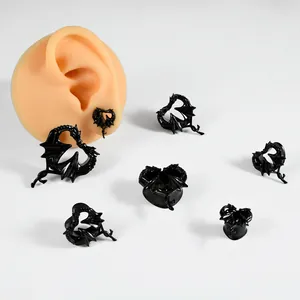 Schwarze Edelstahl-Ohrstecker mit Drachen-Herz-Motiv in verschiedenen Größen am Ohrmodell