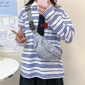 Detail shot of a trendy grey star pattern chest bag worn by a model in a casual outfit