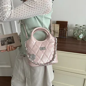 Detail of pink quilted bucket bag with silver chain and glossy finish