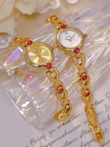 Primer plano de relojes dorados vintage de estilo francés con gemas de color rojo