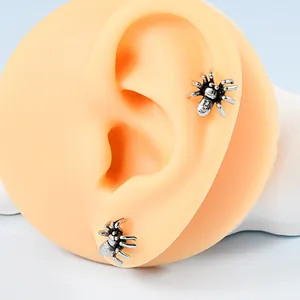 Detailansicht von Vintage-Silberspinne-Ohrsteckern an einem Silikon-Modellohr für Schmuck