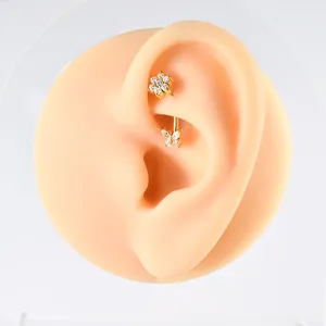 Detailed view of 16g stainless steel curved barbell with butterfly and flower zircon