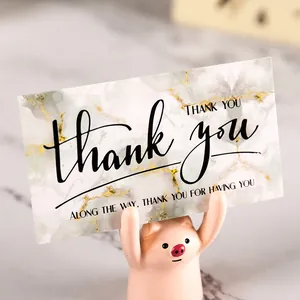 Elegant white marble texture thank you card displayed with a cute pink pig holder accessory