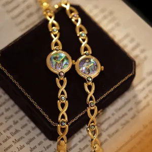 Primer plano detallado de un elegante reloj vintage dorado con esfera de nácar de abulón