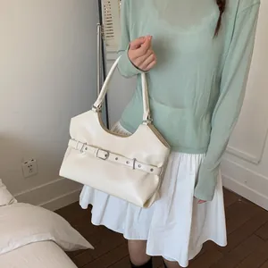 Close-up detail of a white glossy underarm tote bag featuring a decorative belt buckle strap design