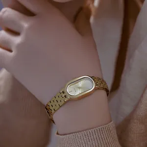 Primer plano de un elegante reloj ovalado vintage dorado para mujer de acero inox