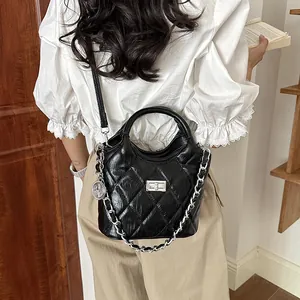 Close-up of elegant black quilted bucket bag featuring a stylish silver chain