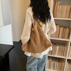Donna che indossa una grande borsa a rete intrecciata in stile francese per le vacanze.