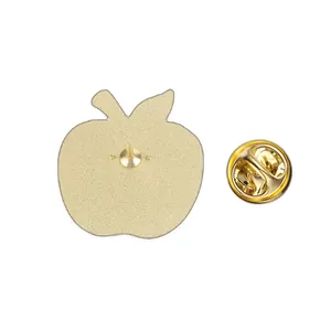 Back detail of a gold-toned apple shaped metal pin badge with a secure butterfly clutch