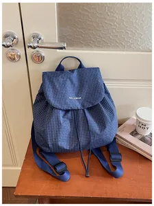 Close-up detail of blue grid pattern on lightweight commuter backpack with brand logo